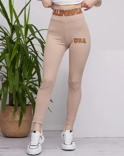 Legginsy / Tregginsy^Royalfashion Beżowe damskie prążkowane legginsy z pomarańczowymi napisami jasny brązowy