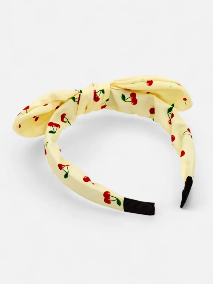 Akcesoria Do Włosów^Royalfashion Dziecięca opaska do włosów z kokardką z printem w wisienki żółty