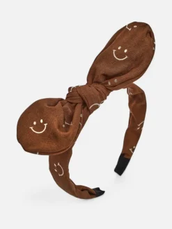 Akcesoria Do Włosów^Royalfashion Dziecięca opaska do włosów z kokardką z printem w uśmiechnięte buźki brązowy