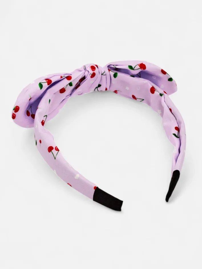 Akcesoria Do Włosów^Royalfashion Dziecięca opaska do włosów z kokardką z printem w wisienki fioletowy