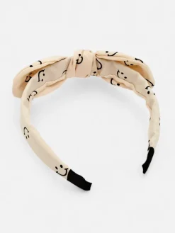 Akcesoria Do Włosów^Royalfashion Dziecięca opaska do włosów z kokardką z printem w uśmiechnięte buźki krem