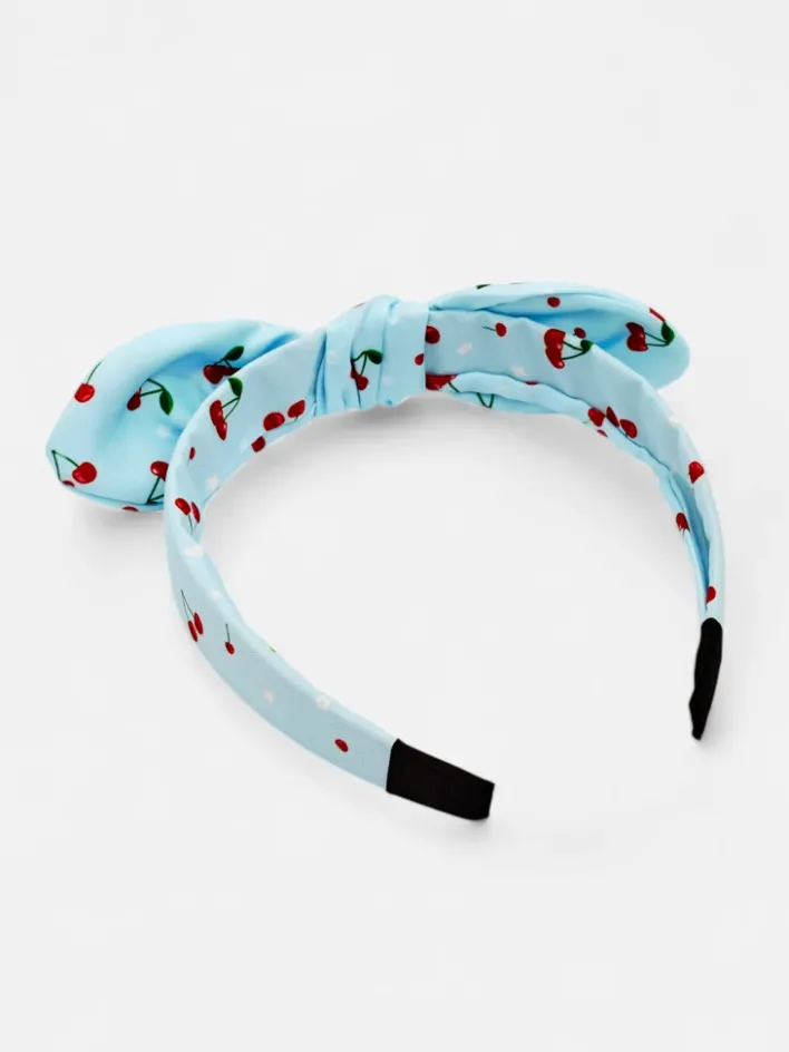 Akcesoria Do Włosów^Royalfashion Dziecięca opaska do włosów z kokardką z printem w wisienki niebieski
